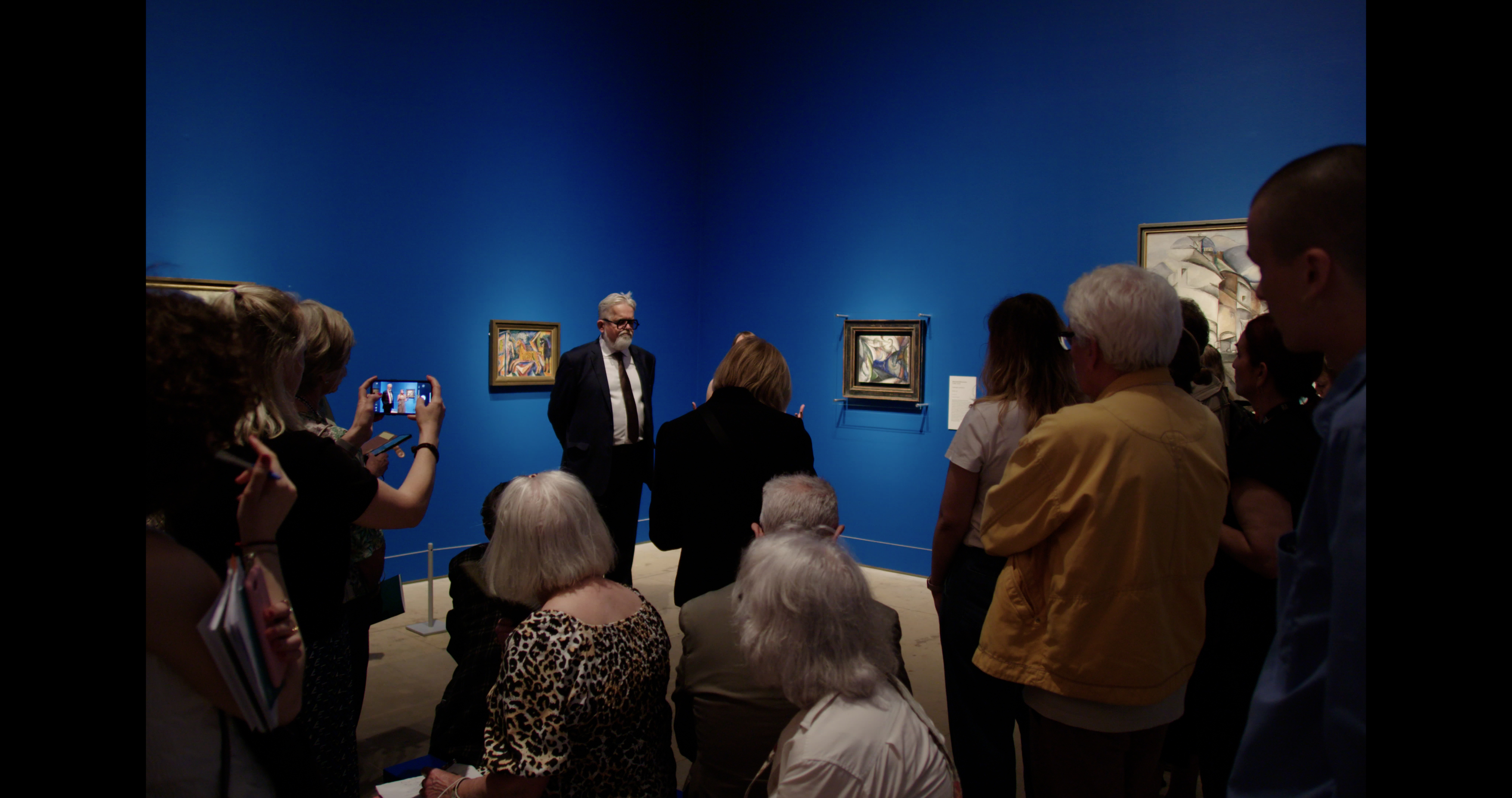 A crowd gathers in a museum.