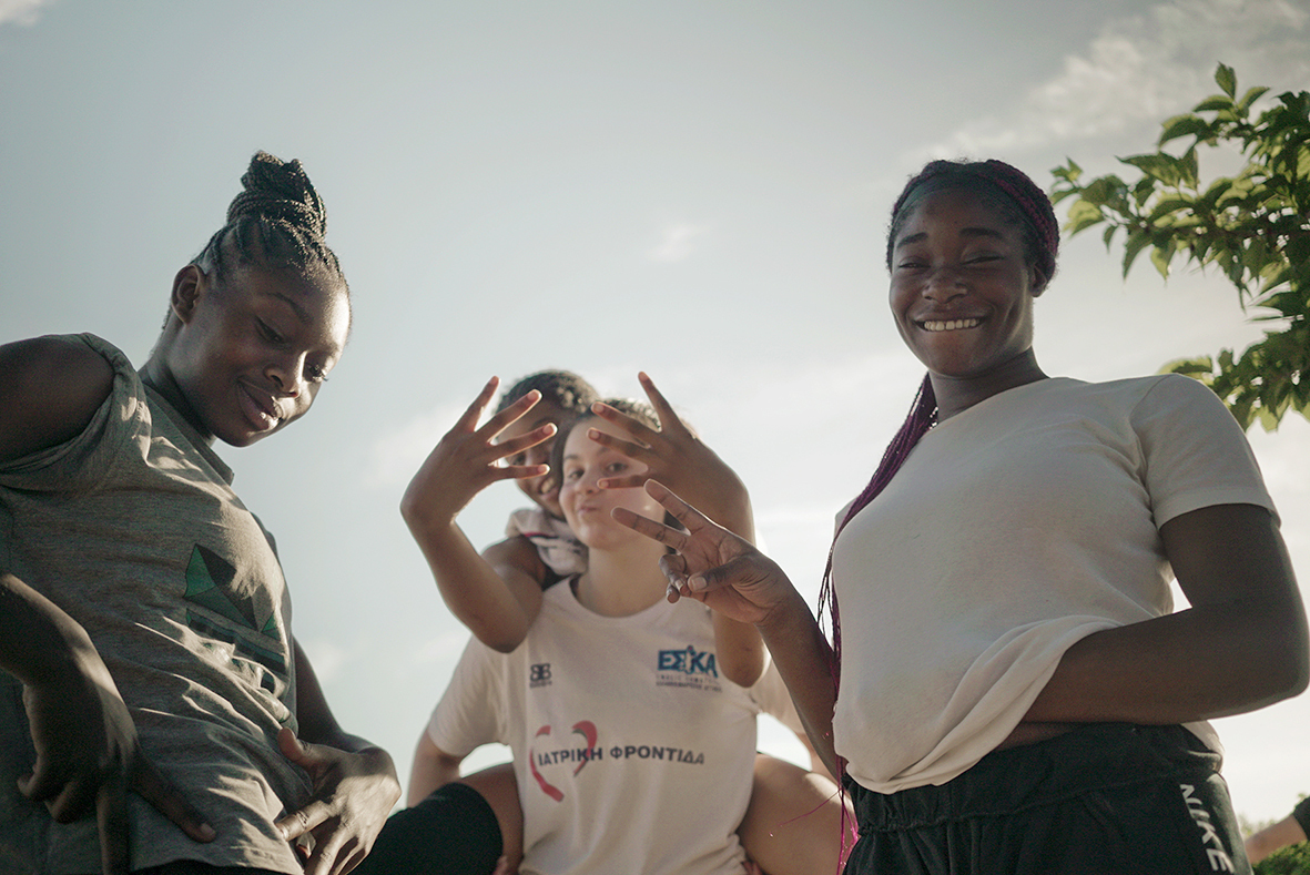 Vier meisjes lachen naar de camera.
