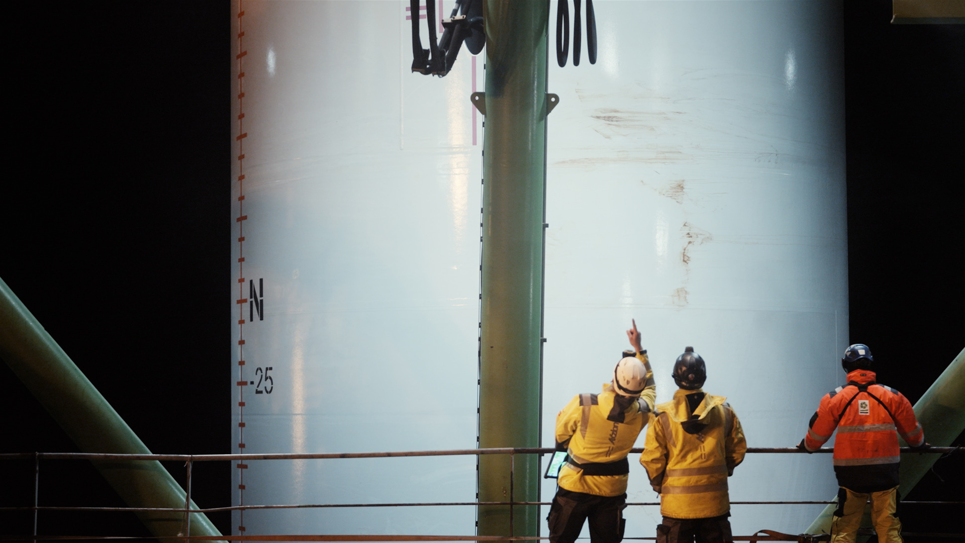 Three people on a drilling platform.