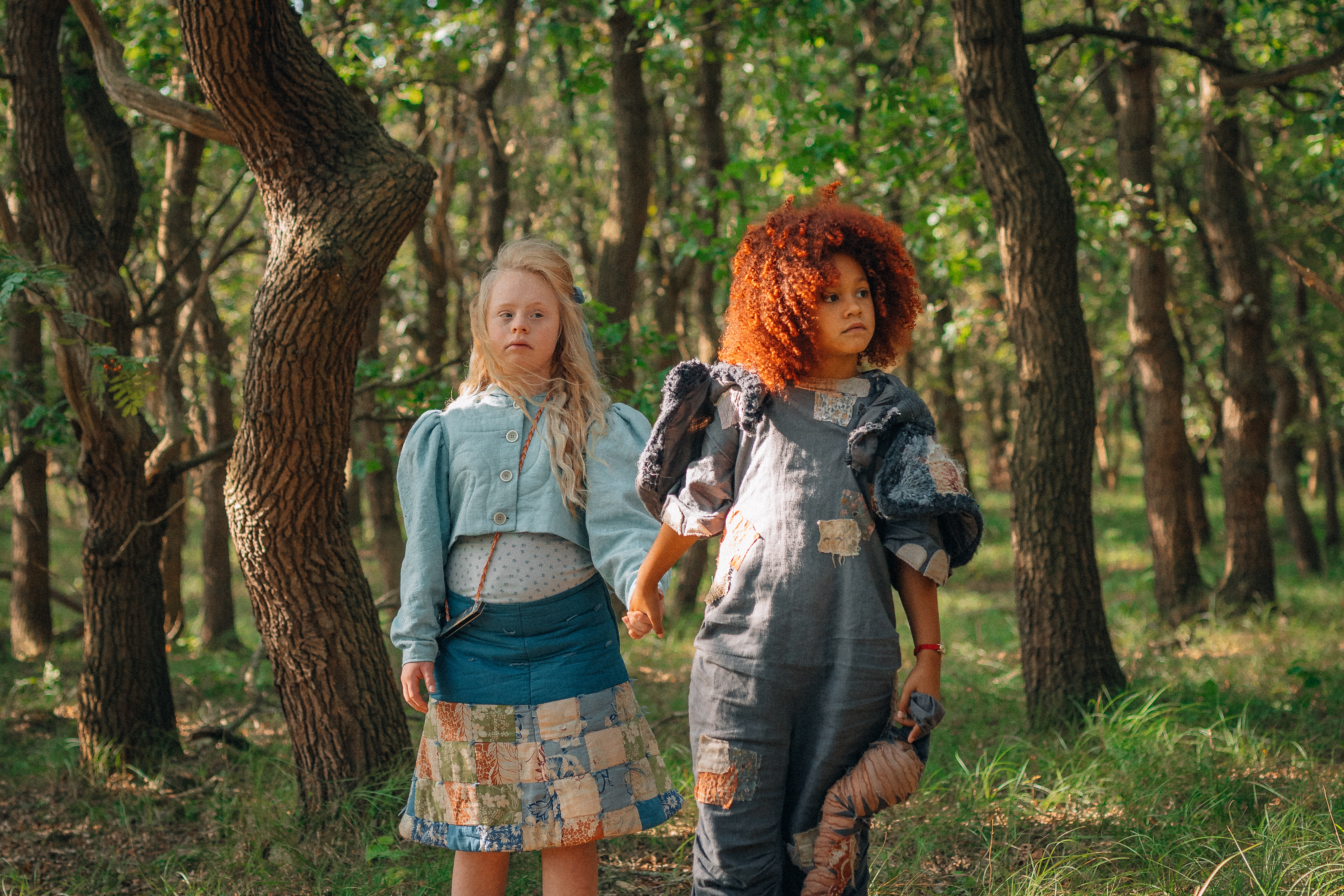 Twee meisjes lopen hand in hand in het bos